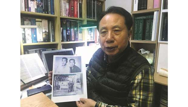Ahn Yong-soo, whose brother was a South Korean prisoner of war captured by communist Vietnamese during the Vietnam War and sold to North Korean military officers, poses for photographs with a picture of his brother, at his home in Seoul, South Korea.