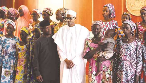 Some of the 21 Chibok schoolgirls released by Boko Haram militants pose during a group photograph with President Muhammadu Buhari and Vice-President Yemi Osinbajo in Abuja, Nigeria in this October 19, 2016 file photo.