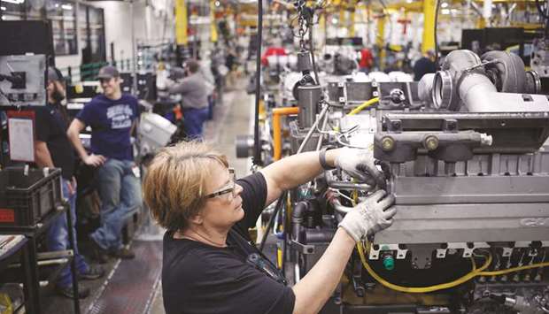 A worker assembles components on a diesel engine at an engine plant in Seymour, Indiana. The US auto industry, which has struggled to adapt to changing technology and consumer tastes, competition and rising steel prices due to the steep tariffs Trump imposed last year, saw production of vehicles plunge 14.4%, while output of parts dropped 3.6%.