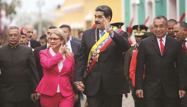 Venezuelau2019s President Nicolas Maduro waving next to his wife Cilia Flores during a commemorative event to mark the bicentennial of the Angostura Congress at the Municipal Palace in Ciudad Bolivar, Bolivar state, Venezuela, yesterday.
