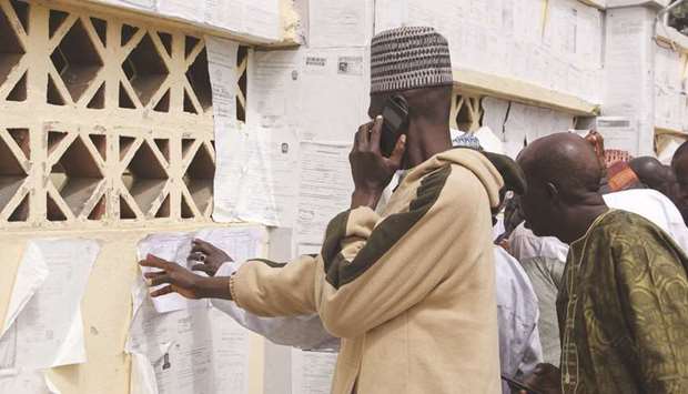 People check their names against the voters roll in Maiduguri in Borno State in north-eastern Nigeria, yesterday.