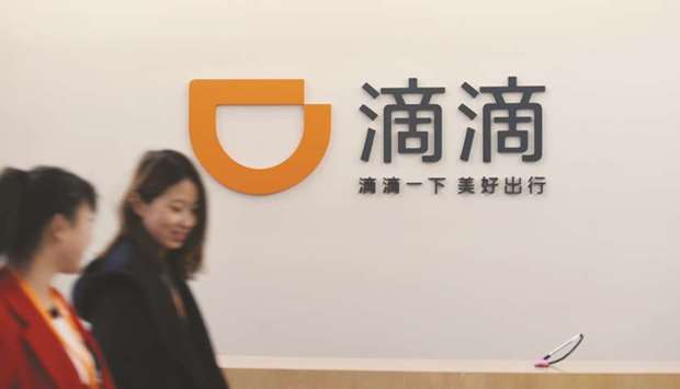 Pedestrians walk past the logo of Didi Chuxing in Beijing. Didi has moved senior executives from China to lead its expansion in markets like Chile and Peru, and began in recent weeks advertising for driver operations, crisis management, marketing and business development personnel in those countries, an analysis shows.