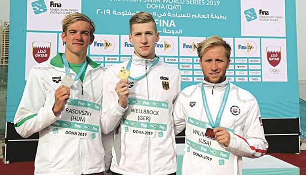 Menu2019s winner Florian Wellbrock (centre), runner-up Kristof Rasovszky (left) and third-placed Jordan Wilimovsky pose with their medals after the FINA Marathon Swim World Series in Doha yesterday.