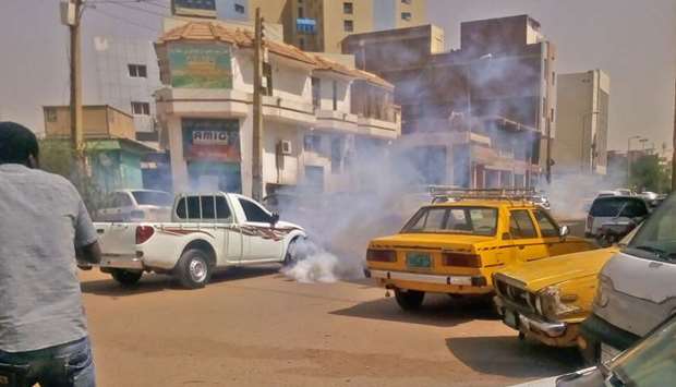Tear gas smoke is seen amidst cars after Sudanese security forces used it to disperse protesters taking part in an anti-government demonstration in Khartoum on February 14.