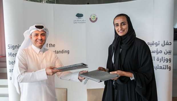 HE Sheikha Hind bint Hamad al-Thani and HE Dr Mohamed Abdul Wahed al-Hammadi exchange the agreement.