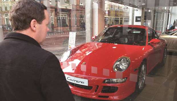 A man looks at a Porsche Carrera for sale in a showroom in London. The warning shot from Volkswagen AGu2019s most profitable division marks the latest sign that the UK failing to reach a divorce deal with the EU could send ripple effects across the industry and affect dealerships, factories and suppliers.