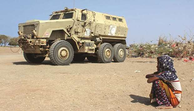 A displaced Yemeni girl sits next to an armoured military vehicle at a camp in the Khokha district of the western province of Hodeidah.