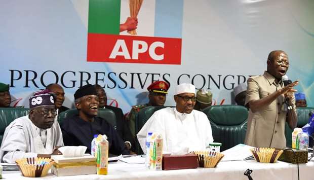 Candidate of the All Progressives Congress (APC), president Mohammadu Buhari (C) sit next to party national leader Bola Tinubu (L) and vice-president Yemi Osinbajo (2ndL) as party chairman Adams Oshiomhole (R) speaks during the party caucus emergency meeting on the postponed general elections in Abuja