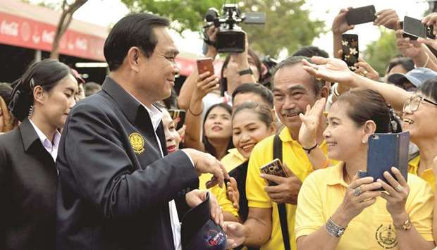 Thai Prime Minister Prayut Chan-O-Cha, left, greeting people at the Chatuchak market in Bangkok yesterday.