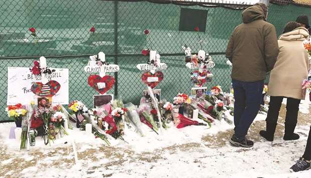 Mourners attend a vigil at Henry Pratt Company in Aurora, Illinois on Sunday.
