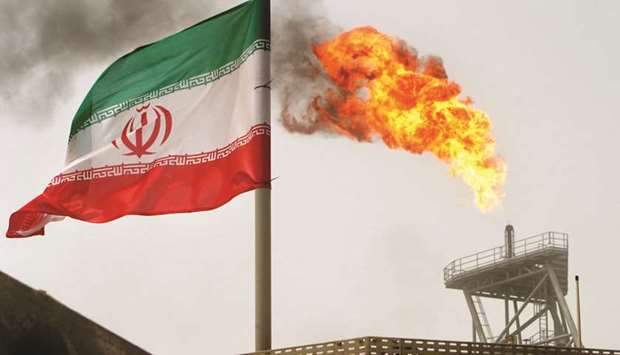 A gas flare on an oil production platform in the Soroush oil fields is seen  alongside an Iranian flag (file). Shipments are averaging 1.25mn bpd in  February, Refinitiv Eikon data showed and a source at a company that tracks Iranian exports said.