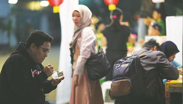 A customer eats a snack at a street stall at night in Jakarta (file). Indonesia is overhauling the halal certification rules as the countryu2019s Shariah economy is set to swell to $427bn by 2022, with halal food alone accounting for more than 50%, according to Bank Indonesia.