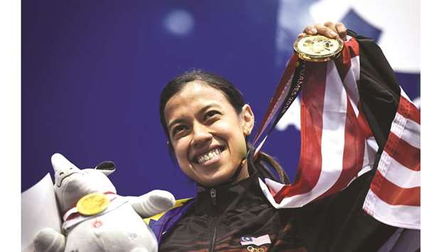 In this file photo taken on August 26, 2018, Malaysiau2019s Nicol David holds up her gold medal during the awards ceremony for the womenu2019s singles squash event at the 2018 Asian Games in Jakarta. (AFP)
