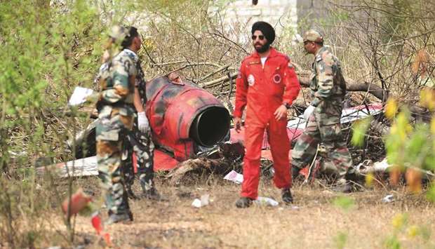 Soldiers stand near the wreckage after two Hawk aircraft of the Surya Kiran aerobatic display team of the Indian Air Force collided in mid-air while rehearsing ahead of Aero India show at the Yelahanka Air Force Station in Bengaluru yesterday.