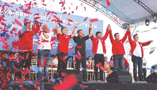 President Rodrigo Duterte raises the hands of some Senate candidates.