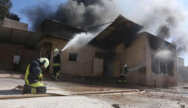Members of the Syrian Civil Defence (The White Helmets), put out a fire at the site of reported air strikes in the town of Khan Sheikhun in the southern countryside of the rebel-held Idlib province, yesterday.