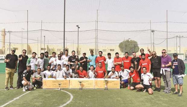 Officials with players and the trophies pose for a commemorative photo.
