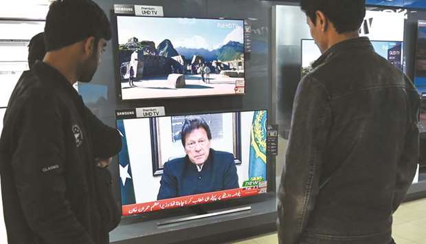 Pakistanis watch as Prime Minister Imran Khan addresses the nation on the bombing attack in Indian-administered Kashmir.