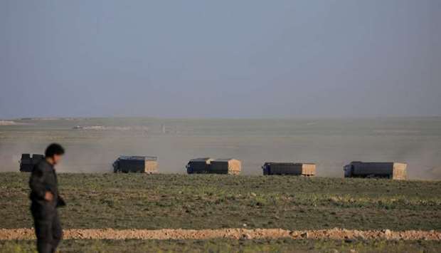Trucks move near Baghouz, Deir Al Zor province, Syria, yesterday.