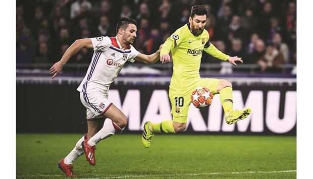 Barcelonau2019s Lionel Messi (right) controls the ball next to Lyonu2019s Leo Dubois during the UEFA  Champions League round of 16 first leg match in Decines-Charpieu, central-eastern France. (AFP)