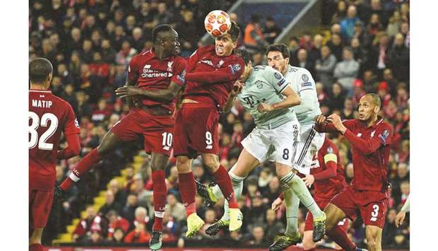 Liverpoolu2019s Brazilian midfielder Roberto Firmino (centre) heads the ball during the UEFA Champions League round of 16, first leg match against Bayern Munich at Anfield stadium in Liverpool, north-west England on Tuesday night. (AFP)