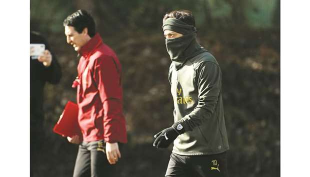 Arsenalu2019s Mesut Ozil (right) and manager Unai Emery during training yesterday. (Reuters)