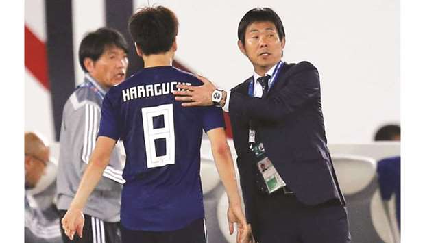Japanu2019s Genki Haraguchi with coach Hajime Moriyasu (right) as he is substituted yesterday. (Reuters)