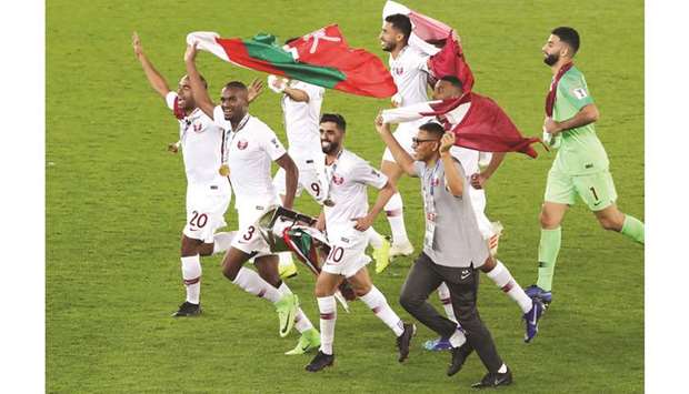 Qataru2019s players celebrate with the trophy after winning the AFC Asian Cup yesterday. (Reuters)