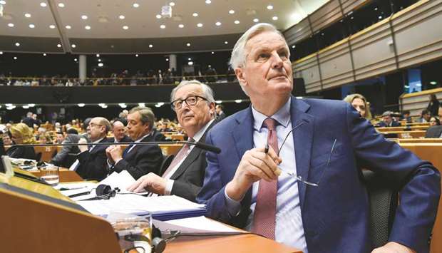 European Chief Brexit negotiator, Michel Barnier (right), flanked by President of the European Union Commission Jean-Claude Juncker (left), looks on during a session of the parliament at the EU headquarters, in Brussels, on January 30.