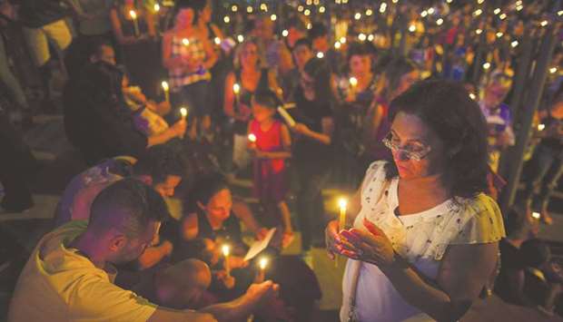 People pray outside the Brumadinho Matriz Church during a service in honour of the missing people and dam collapse victims.