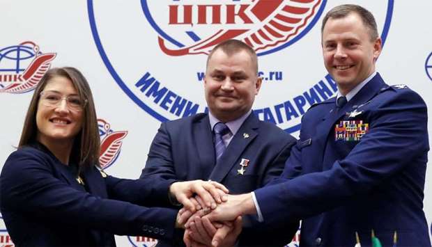 ISS crew members Aleksey Ovchinin of Russia and Nick Hague of the US, along with Christina Koch of the US pose for a photograph during a news conference in the Star City near Moscow