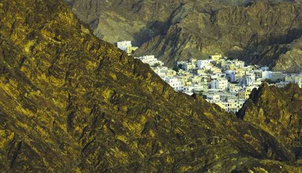 The traditional houses of the old city district sit surrounded by mountains in Muscat