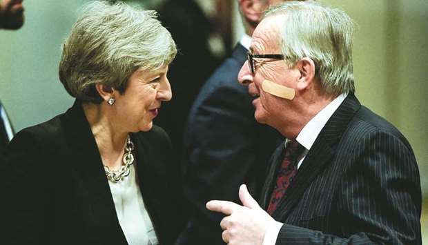 European Commission President Jean-Claude Juncker gestures as he welcomes British Prime Minister Theresa May after her arrival at the EU headquarters in Brussels to hold a meeting on Brexit talks on February 20.