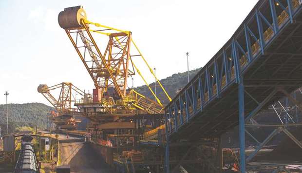 Crushed iron ore fills cargo train wagons aside a conveyor belt at Valeu2019s iron ore Brucutu mine (file). Iron ore has spiked after Vale suffered from a dam burst in January and announced cuts of up to 70mn tonnes, although some of that drop can be offset.