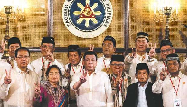 President Rodrigo Duterte gives a peace sign with Moro Islamic Liberation Front (MILF) chairman Murad Ebrahim (front third right) during the Ceremonial Confirmation of the Bangsamoro Organic Law Plebiscite Law Canvass Results and Oath-taking of Transition Authority at the Malacanang palace in Manila, yesterday.