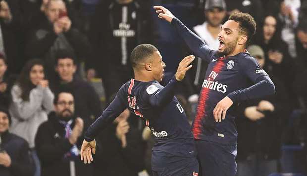 Paris Saint-Germainu2019s Layvin Kurzawa (R) celebrates with Kylian Mbappe after he scored a goal against Montpellier at the Parc des Princes stadium on February 20.