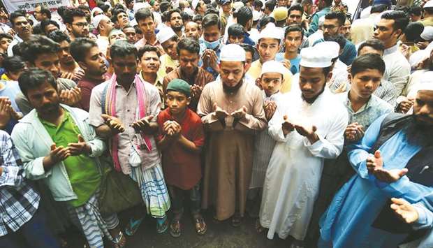 People pray for the victims of a fire in Dhaka yesterday.