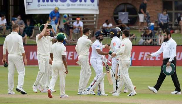 Sri Lanka's Kusal Mendis (C) shakes hands with South African players after matching SA's score to win by 8 wickets on the third day of the second Test cricket match between South Africa and Sri Lanka at St. George's Park Stadium in Port Elizabeth