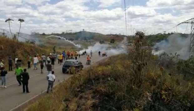 People look on as tear gas this thrown in Santa Elena De Uairen, Venezuela