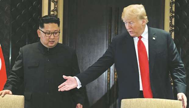 US President Donald Trump (right) gestures as he and North Koreau2019s leader Kim Jong-un arrive for a signing ceremony during their historic US-North Korea summit, at the Capella Hotel on Sentosa island in Singapore on June 12, 2018. Trump and Kim are preparing for a second summit in Vietnam this week.