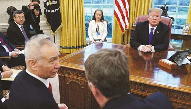 US President Donald Trump watches as Chinau2019s Vice Premier Liu He (left) speaks with US Trade Representative Robert Lighthizer (right) in the Oval Office of the White House in Washington. Trump and US Treasury Secretary Steven Mnuchin said the two sides had reached an agreement on currency issues, but did not give details.