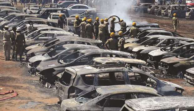 Firefighters extinguish smouldering cars after a fire broke out in a parking lot during the Aero India show at the Yelahanka Air Force Station in Bengaluru, yesterday.