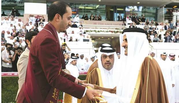 His Highness the Amir Sheikh Tamim bin Hamad al-Thani presents the Amiru2019s Sword to Faleh Suwead al-Ajami, who won the feature event at the HH The Amiru2019s Sword Equestrian championship at Qatar Equestrian Federationu2019s outdoor arena yesterday.