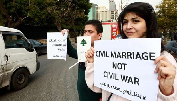 Lebanese demonstrators carry placards during a gathering against the ongoing ban on civil unions outside the Ministry of Interior in the capital Beirut, yesterday.