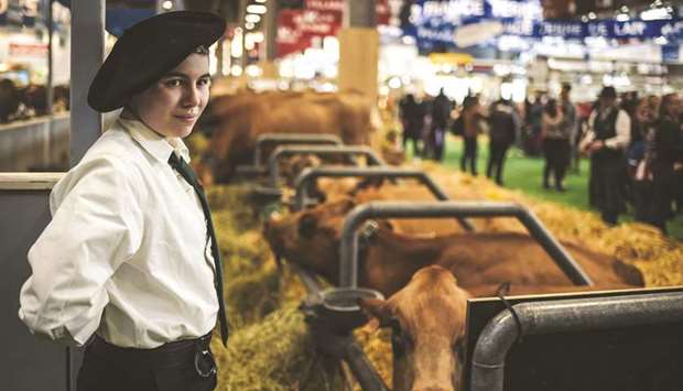 A young farmer stands near her cows during the International Agriculture Fair (Salon international de lu2019Agriculture) in Paris.