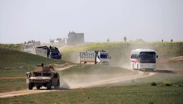 Trucks loaded with civilians ride near the village of Baghouz, Deir Al Zor province, Syria
