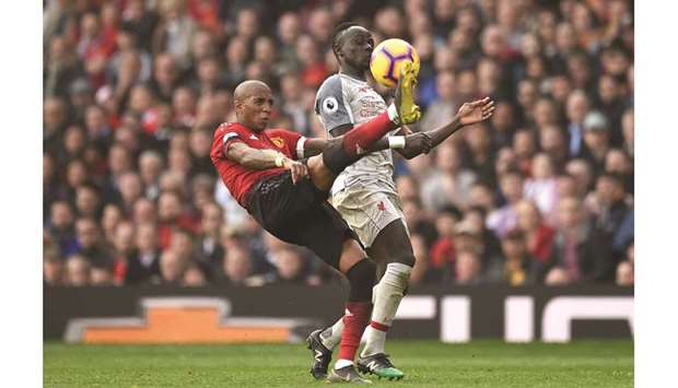 Manchester Unitedu2019s English midfielder Ashley Young (L) clears from Liverpoolu2019s Senegalese striker Sadio Mane (R) during their English Premier League match at Old Trafford in Manchester, north west England, yesterday.
