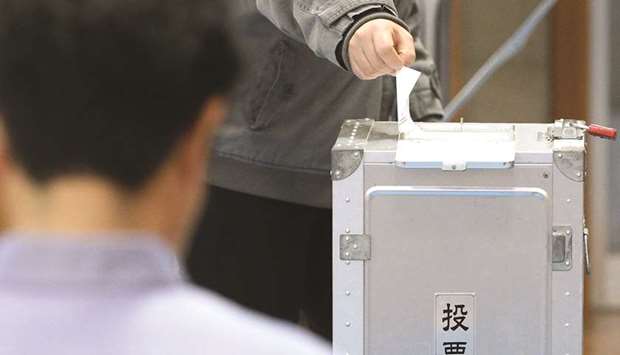 A Japanese resident casts his ballot at a polling station in Ginowan.