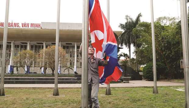 A worker places a North Korean flag outside a media centre ahead of the North Korea-US summit in Hanoi, Vietnam.