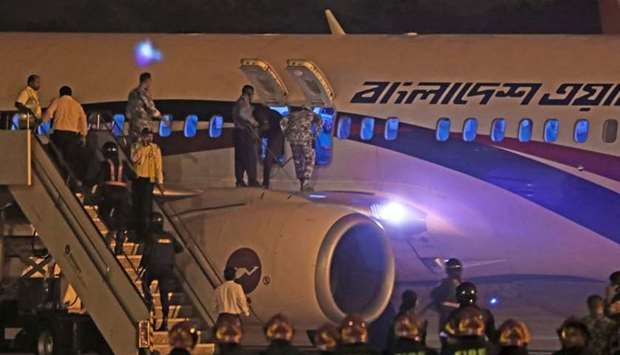 Bangladeshi security personnel stand guard near a Dubai-bound Bangladesh Biman plane on the tarmac of the Shah Amanat International Airport in Chittagong yesterday, following an emergency landing after a man apparently attempted to hijack the aircraft